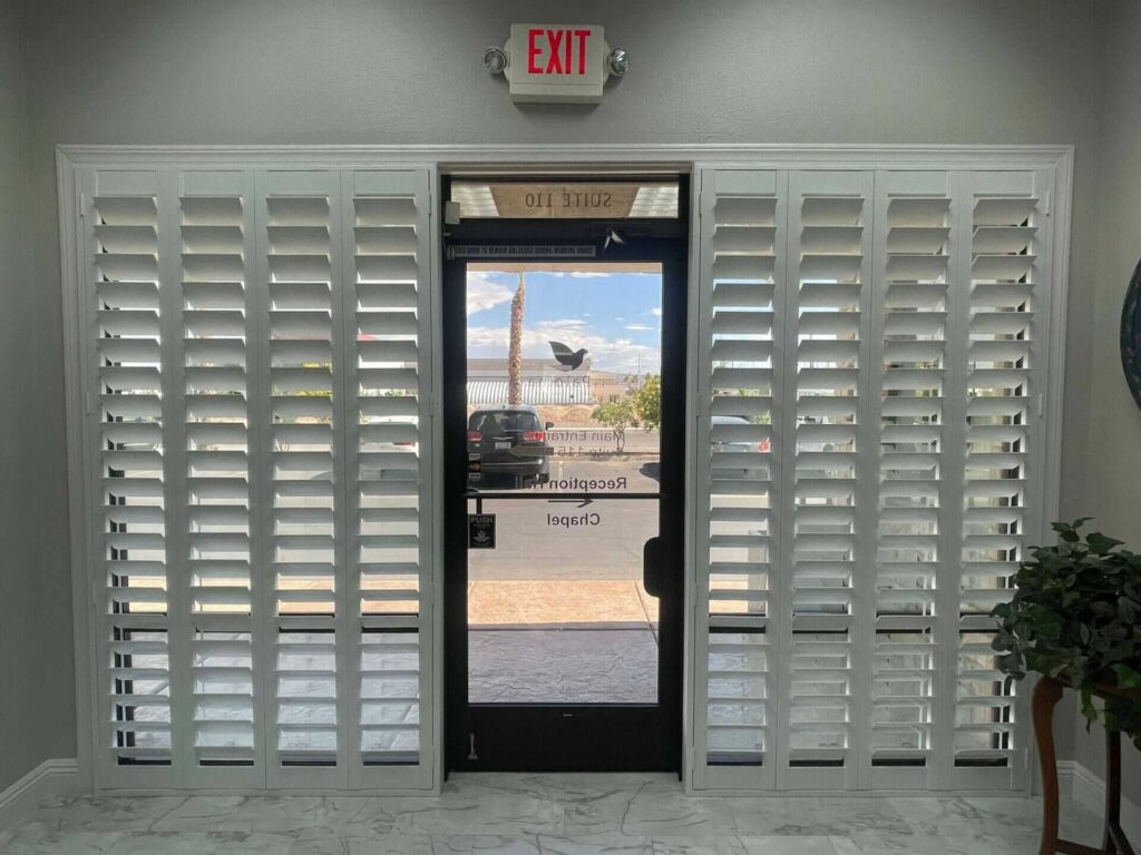 Vertical shutters flank the glass door, providing a clean, modern look for this office entryway.
