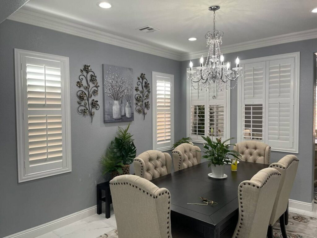 White plantation shutters contrast beautifully with gray walls in this elegant dining room.