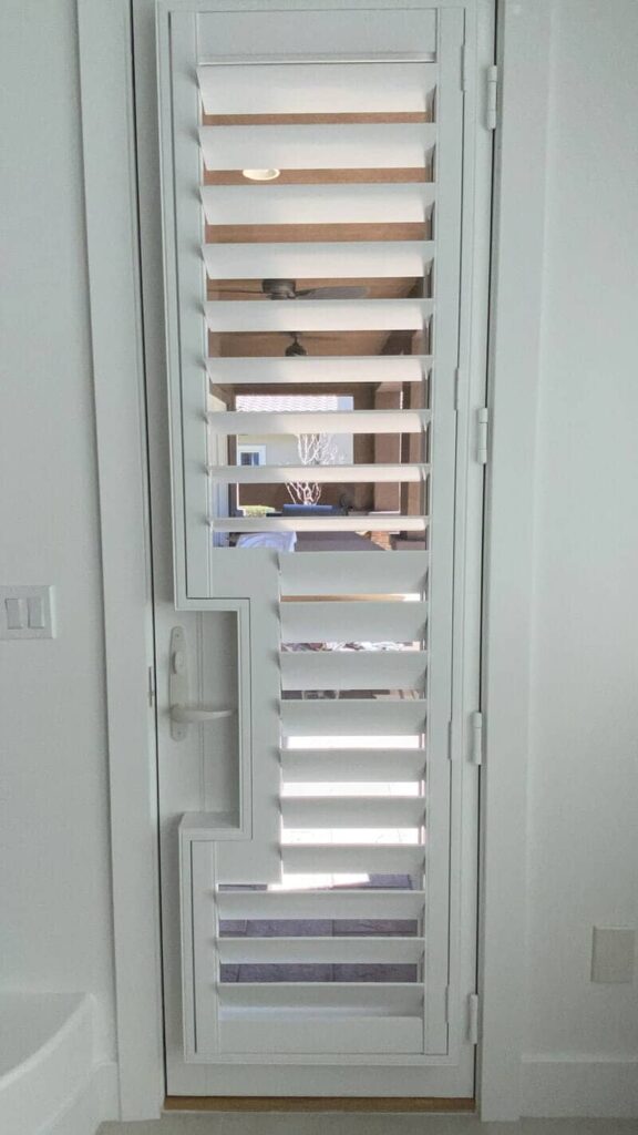 A full-length white shutter is custom-cut for the door handle, offering complete control over the light.