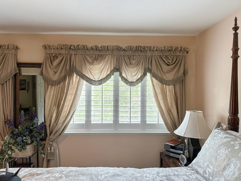 Soft drapes paired with classic bedroom shutters