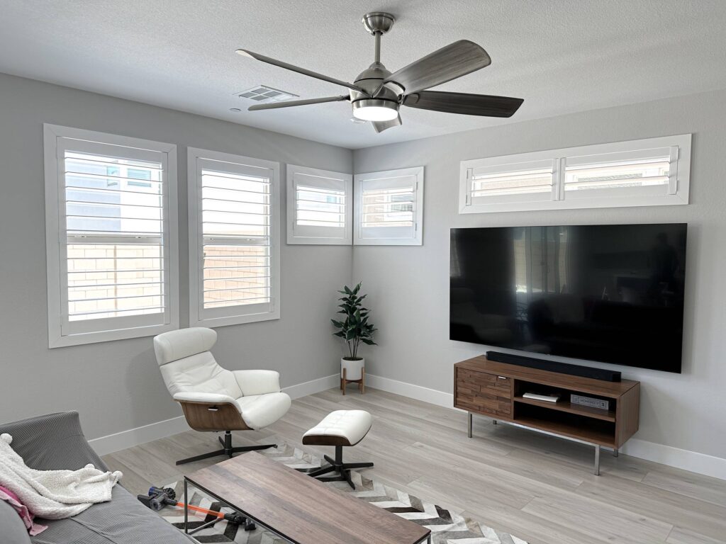 Multiple white plantation shutters provide a clean, contemporary look in this media room.
