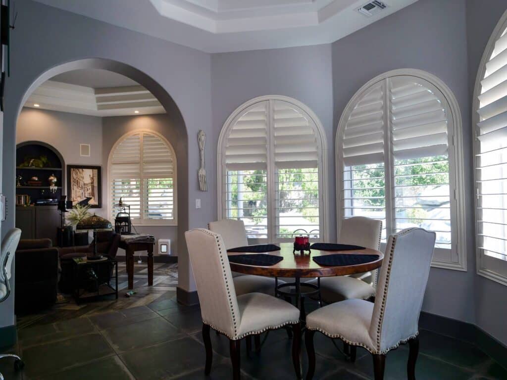 Elegant dining room shutters frame a bright, inviting space.