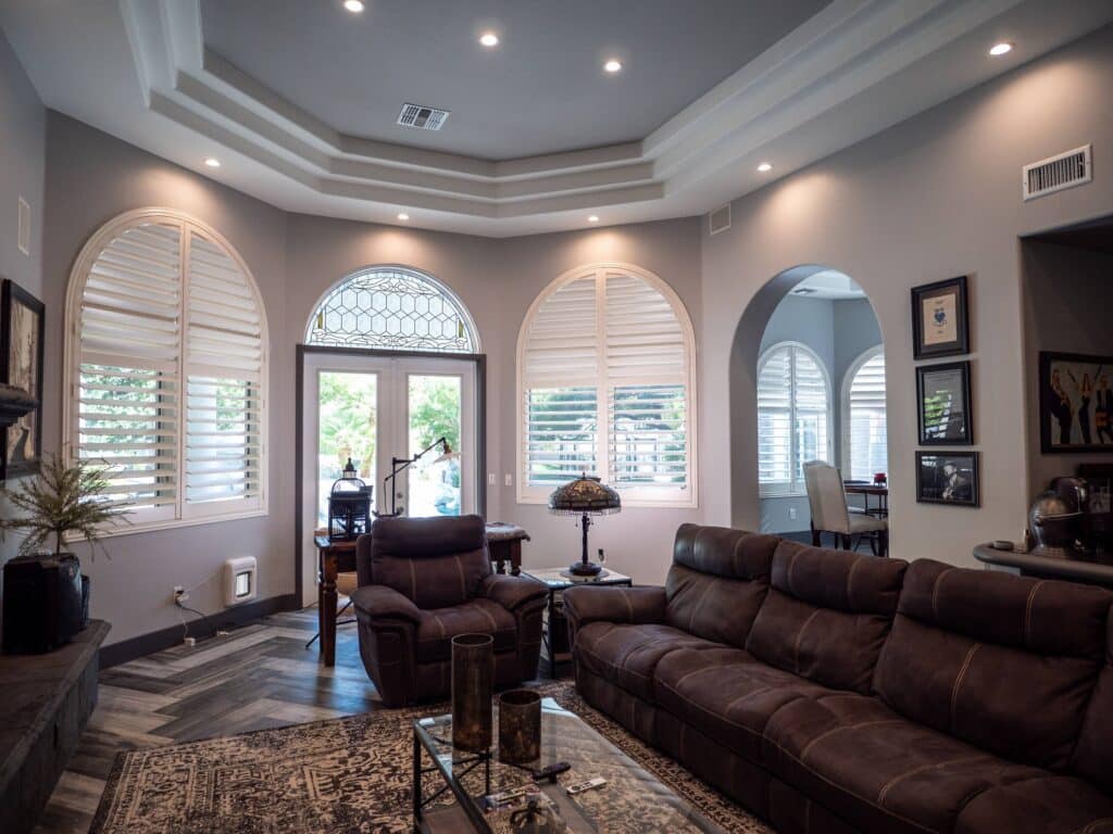 Arched shutters and French doors highlight the grand living room architecture.