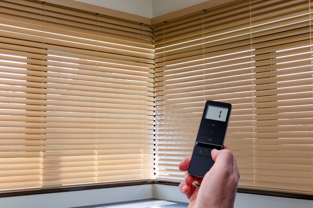A person uses a remote to operate their blinds.