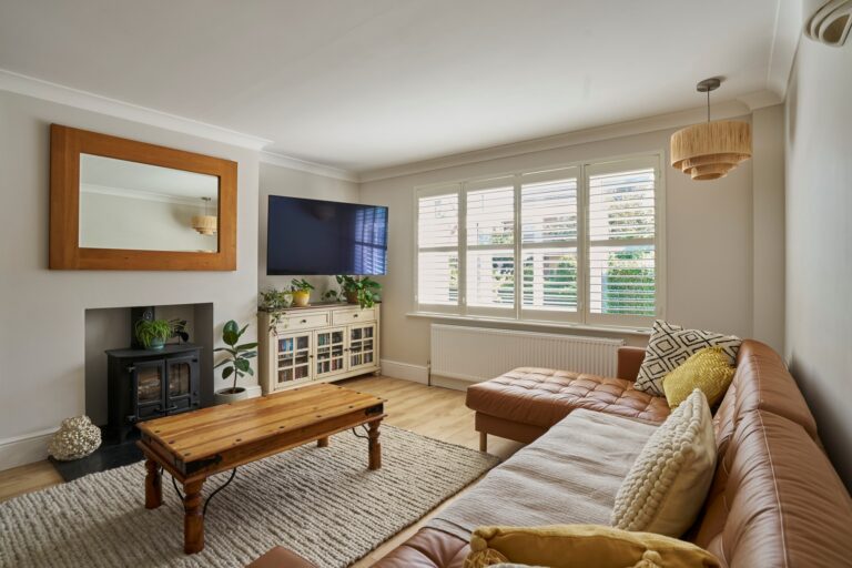 A living room with shutters on the window.